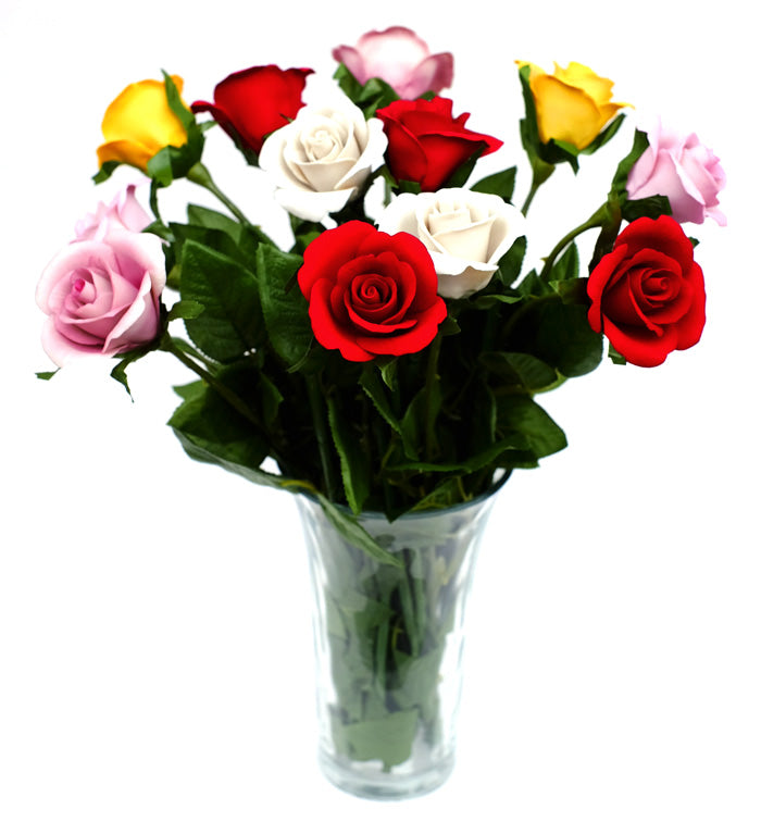 Porcelain roses bouquet of mixed colors in glass vase on white background